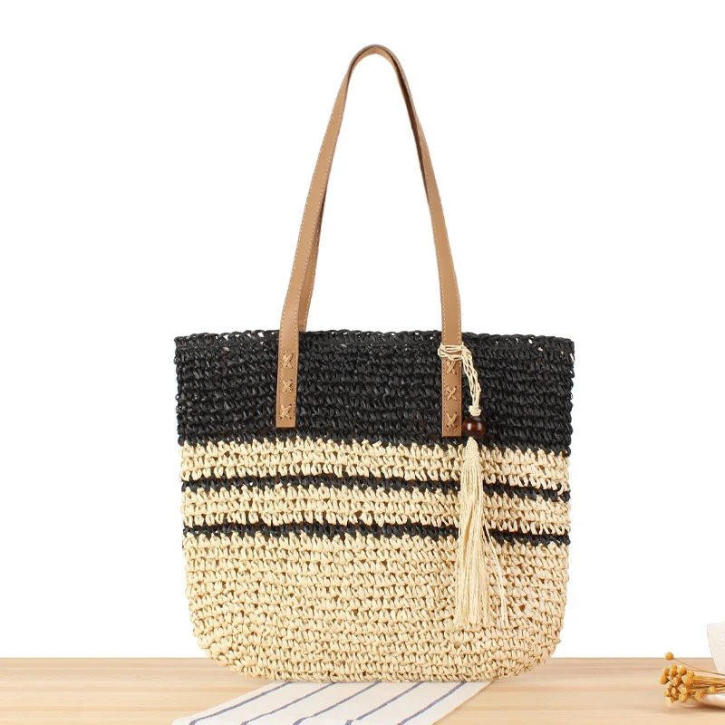 Handtasche aus geflochtenem Naturmaterial mit dekorativem Quastenanhänger Skanto