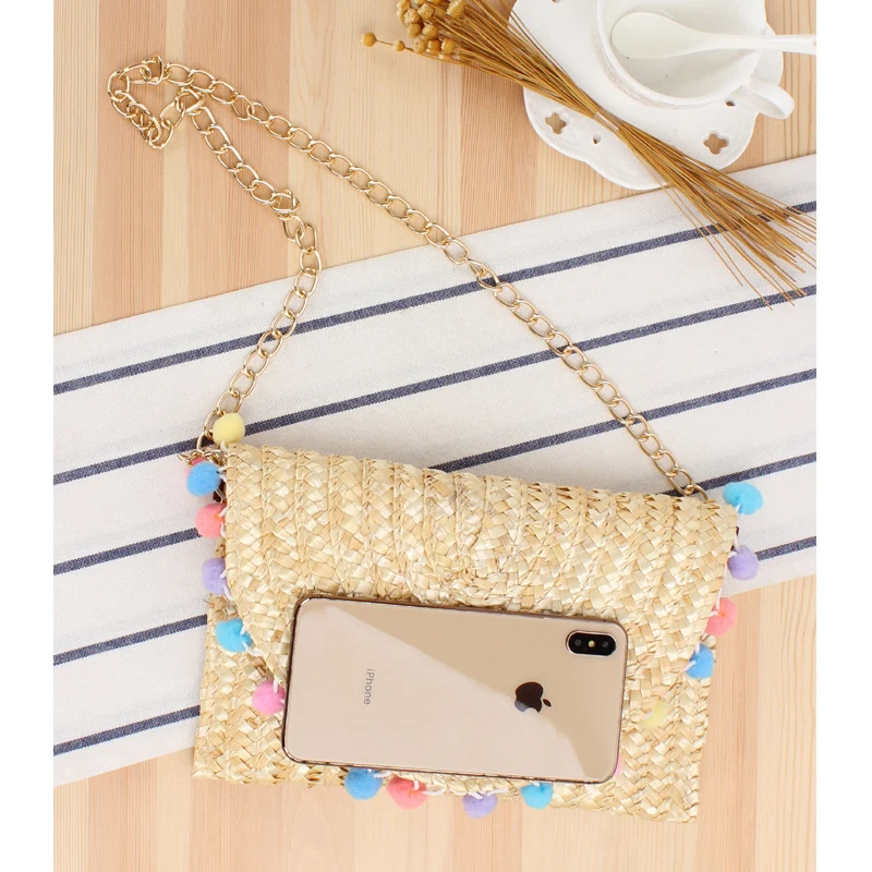 Handgewebte Clutch aus Naturmaterial mit dekorativen Pompons Skanto